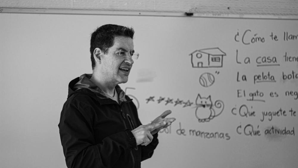 how do you say warehouse in spanish-A Spanish teacher explaining language concepts on a whiteboard in class.